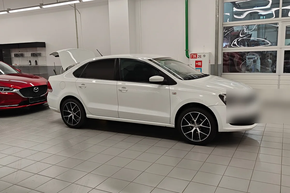 Белый Volkswagen Polo седан до рестайлинга в автосалоне
